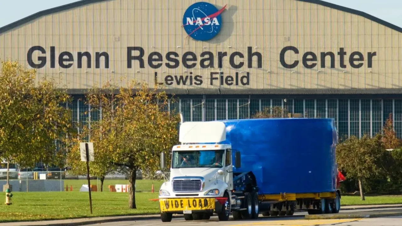 A transport truck with NASA's Glenn Research Center in the background.
