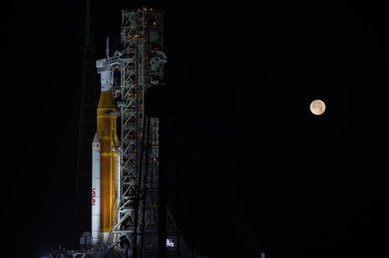 Artemis I Space Launch System (SLS) with full moon.