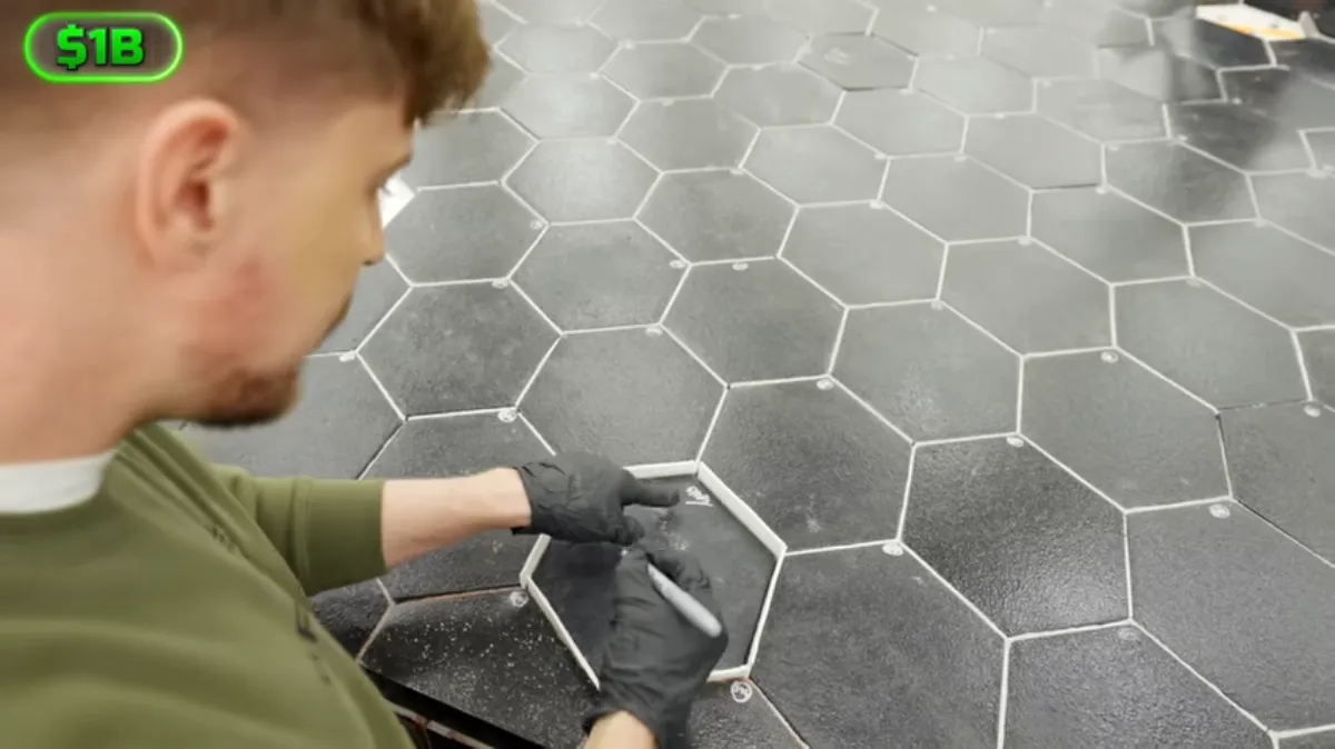 MrBeast signing a SpaceX Starship heat shield tile.