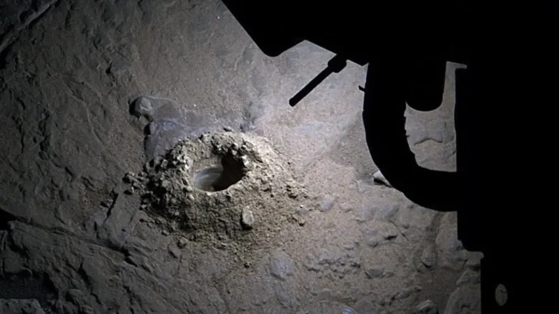 Curiosity rover using LED lights to illuminate a hole it had drilled.