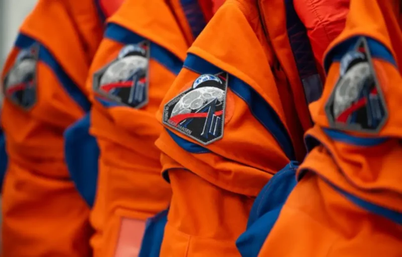 Orange flight suits with Artemis mission patches.