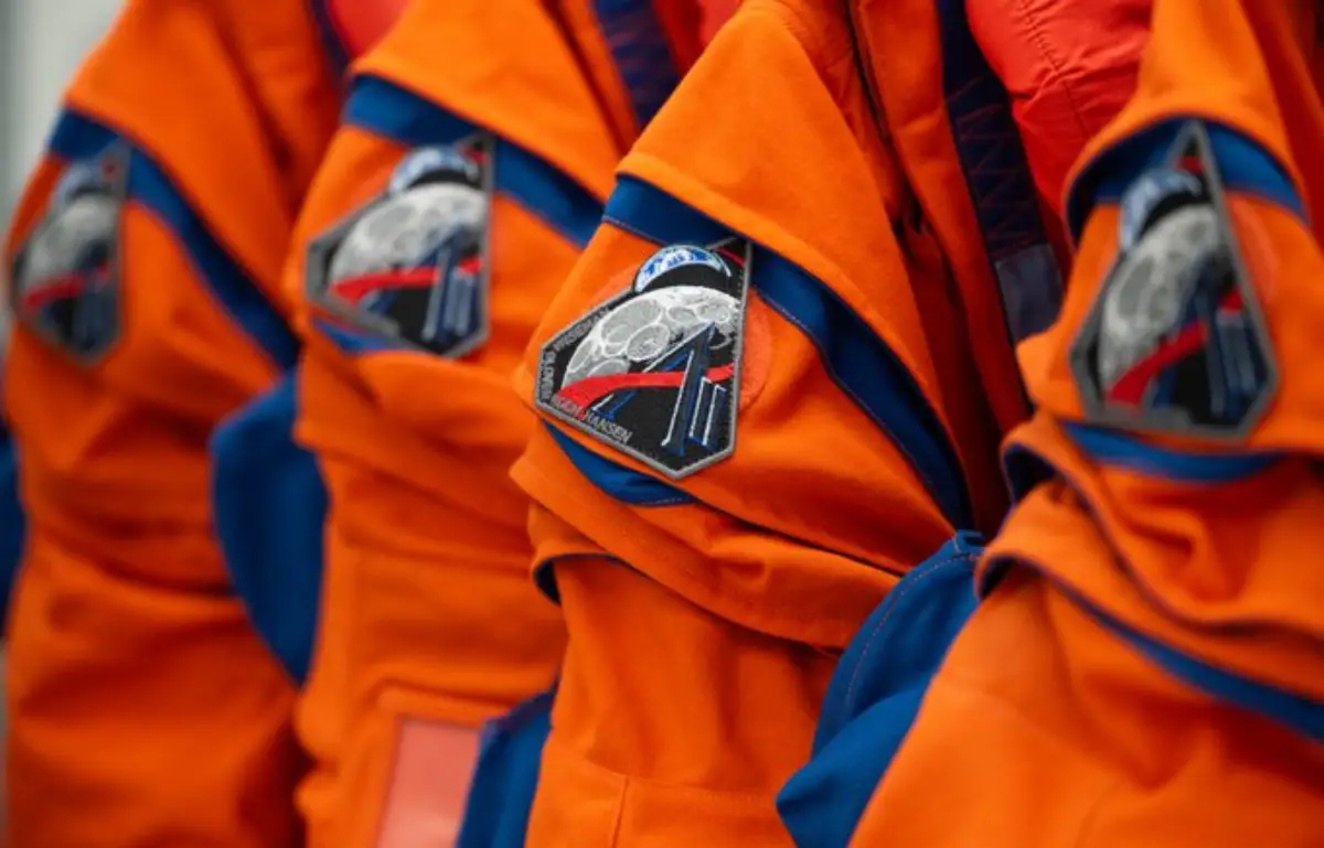 Orange flight suits with Artemis mission patches.